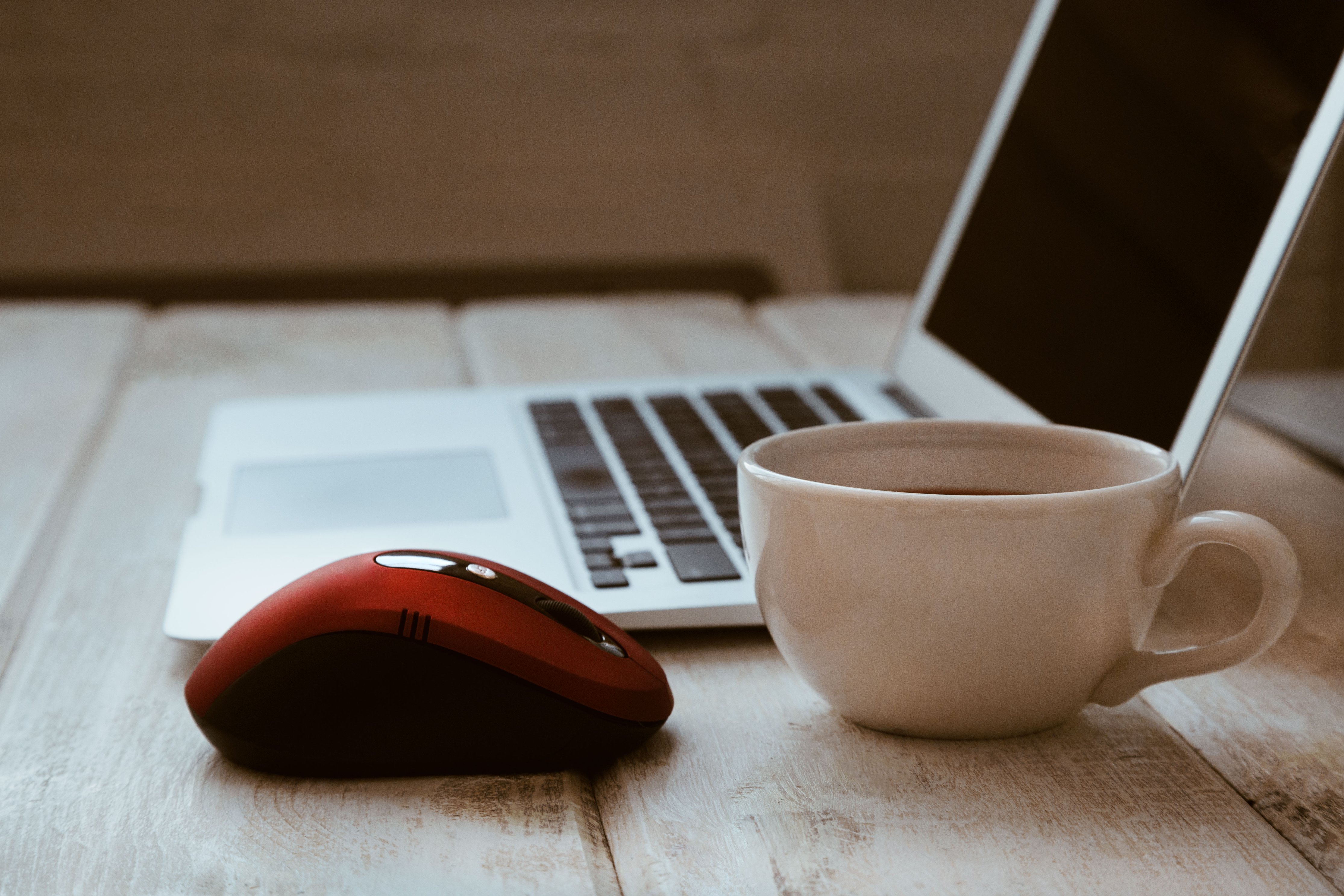 laptop, red mouse and coffee mug